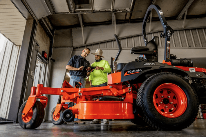 Workers doing maintenance check on mower