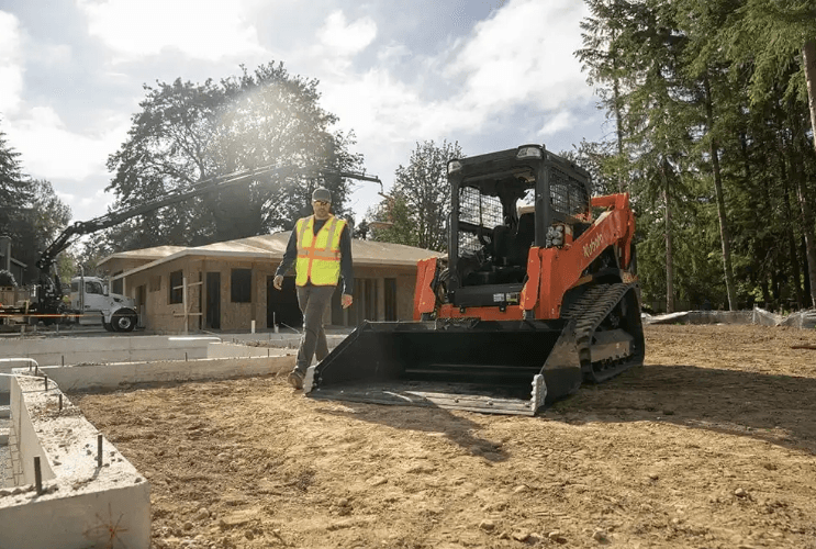 Man walking close to a Track Loader