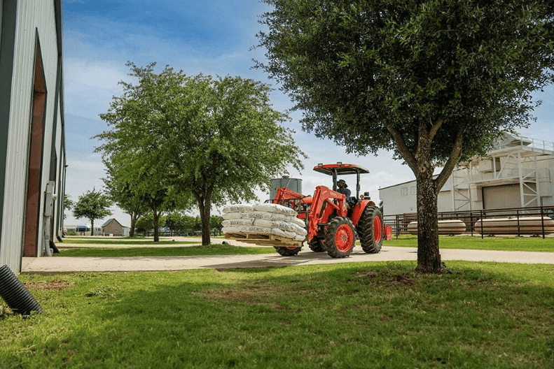Man using Utility Tractor to move pallet of material 